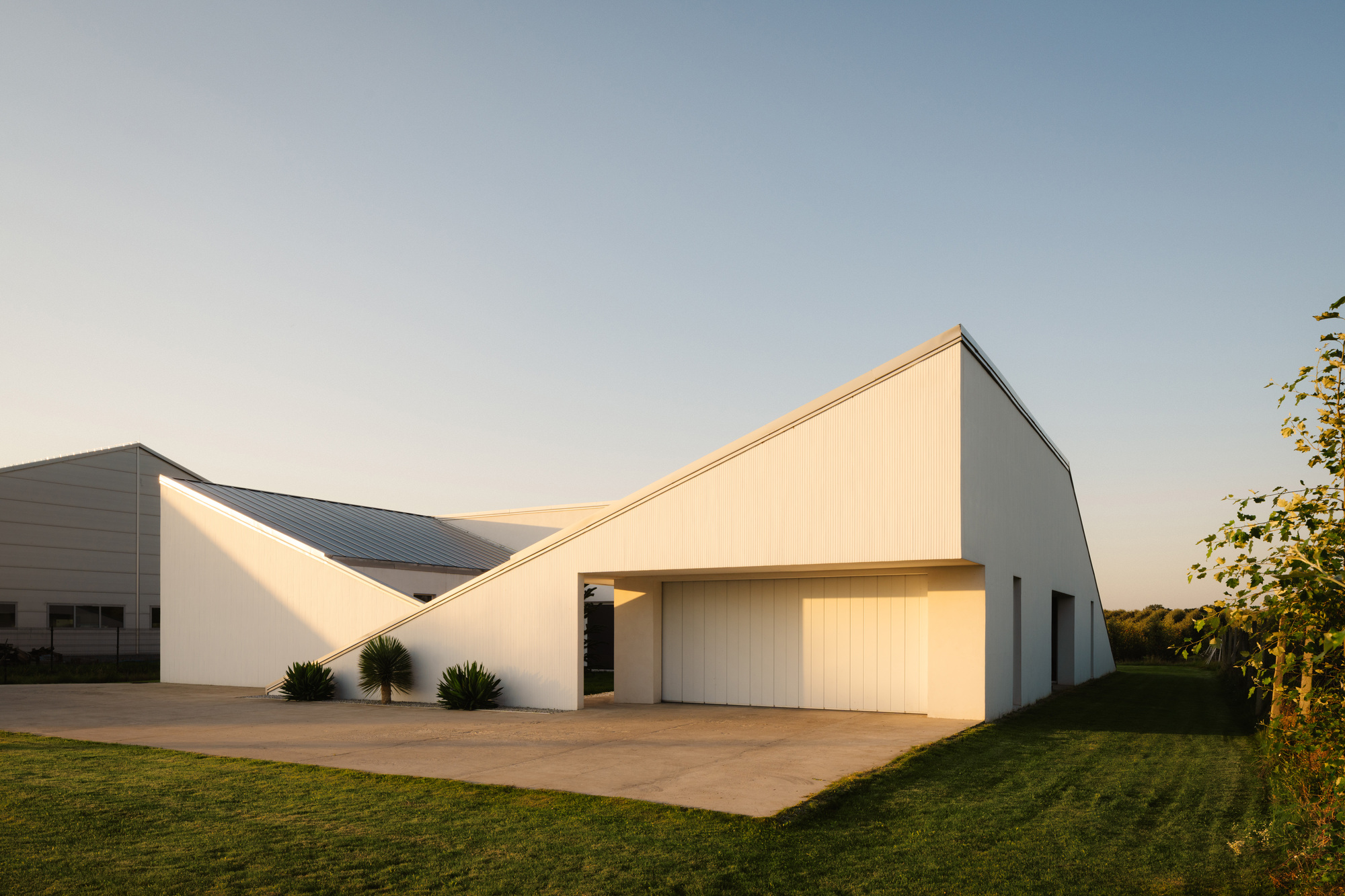 Slope House / SOURCE Architecture Studio — дом со скатной крышей, переходящей в рельеф