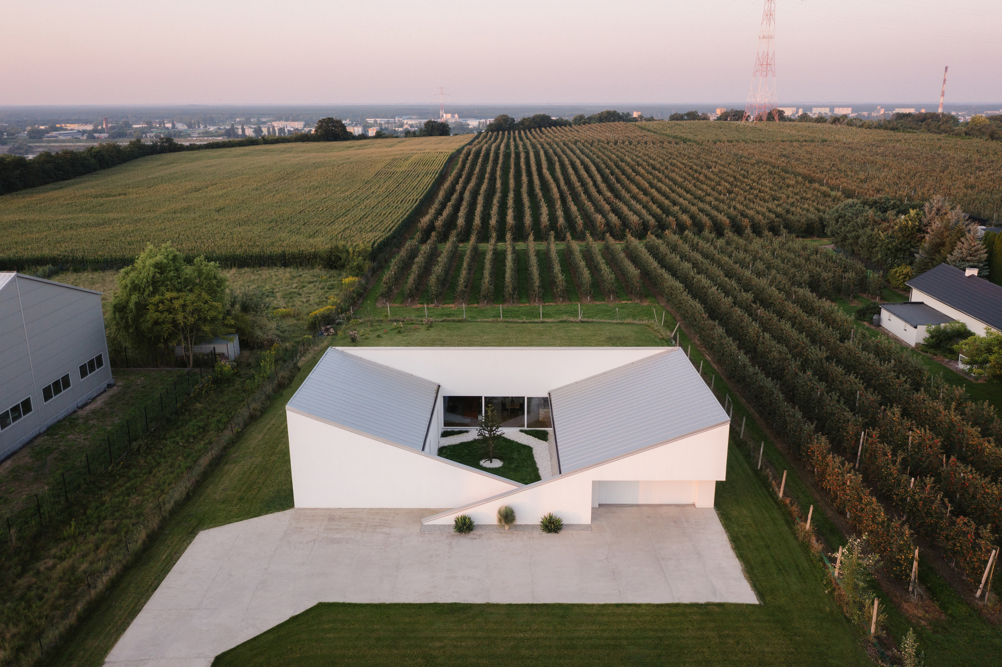 Slope House / SOURCE Architecture Studio — дом со скатной крышей, переходящей в рельеф