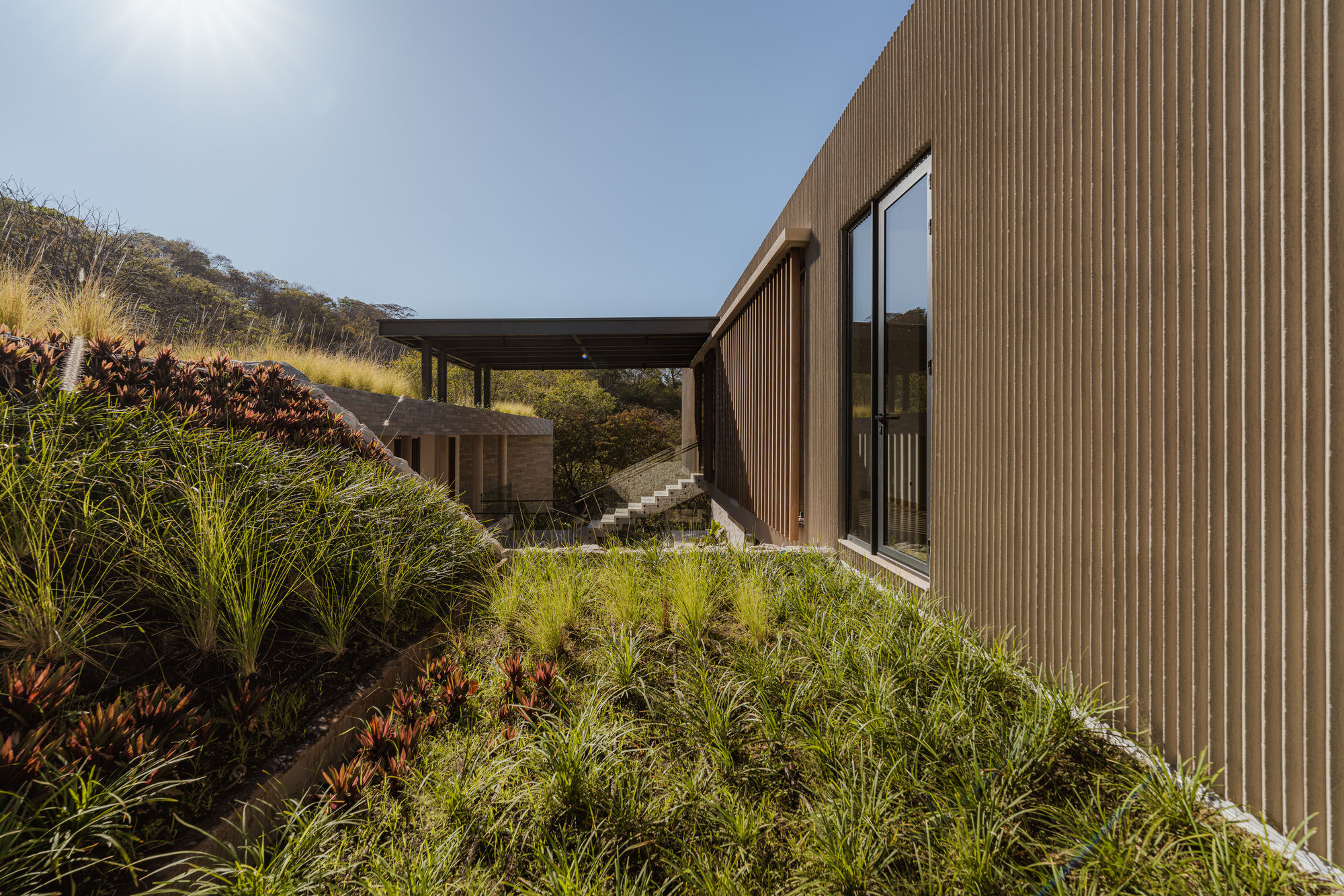 Casa Continuum / Inverse Project: дом, встроенный в склон тропического холма в Коста-Рике