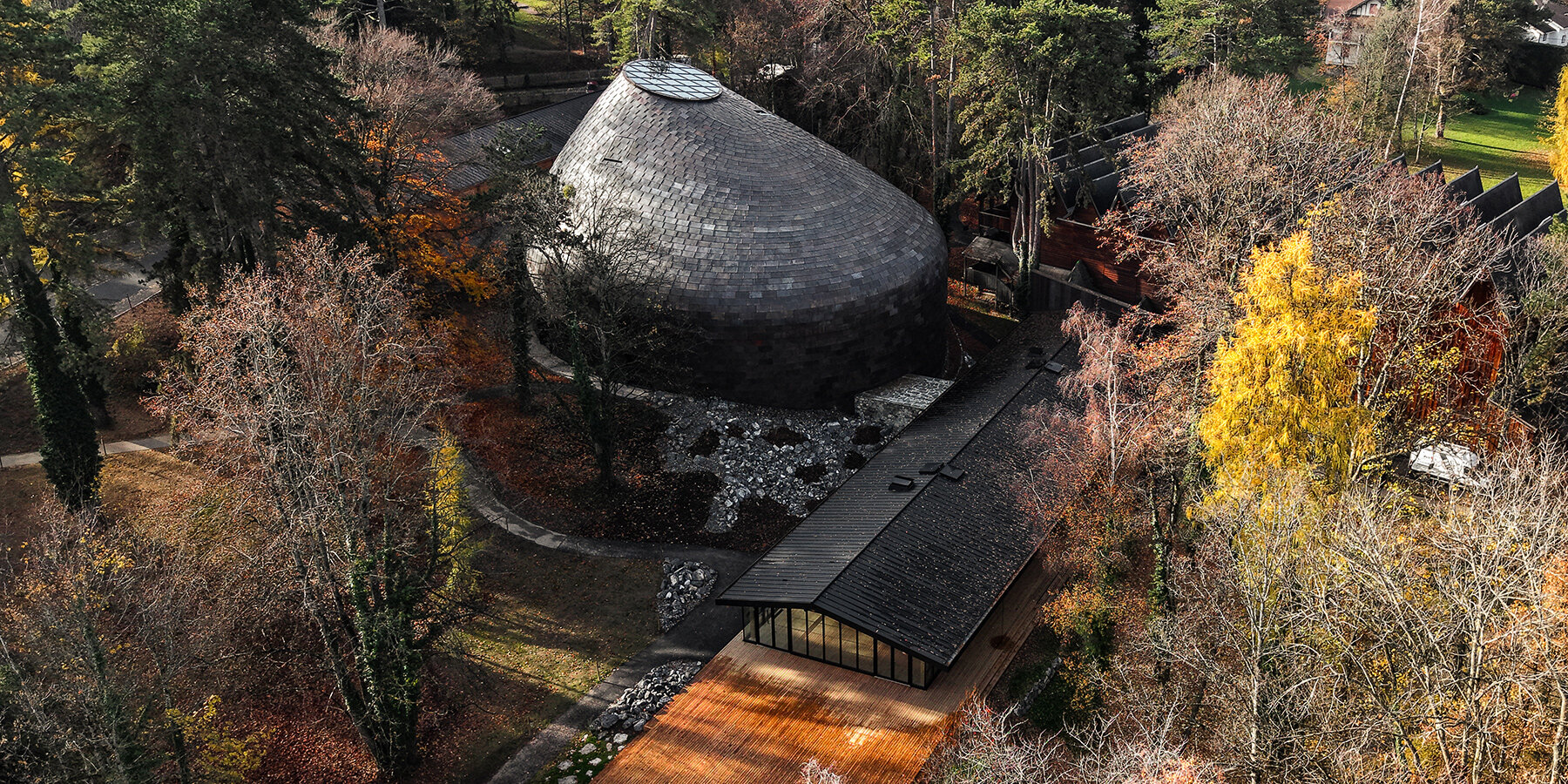 Copper shingles wrap curving concert hall ‘La Source Vive’ in Évian, France