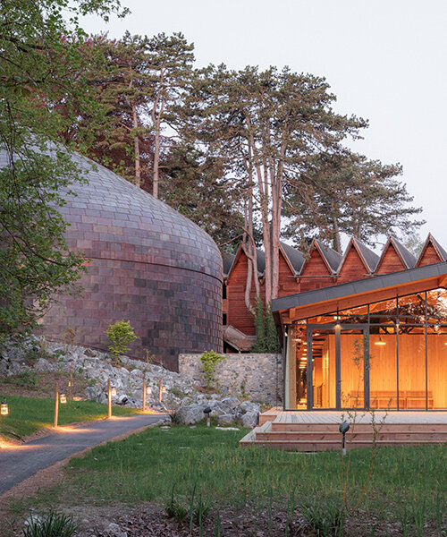 Copper shingles wrap curving concert hall ‘La Source Vive’ in Évian, France