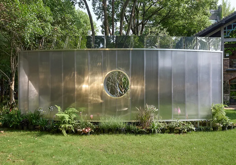 Curved mirrored steel walls multiply one tree into a forest in Infinite Grove pavilion in Shanghai